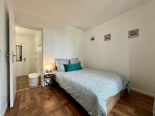Un dormitorio con una cama con almohadas azules. en cocon de Villeneuve-4 pers. en Villeneuve-sur-Yonne