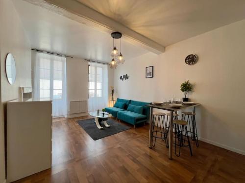 un salon avec un canapé bleu et une table dans l'établissement cocon de Villeneuve-4 pers., à Villeneuve-sur-Yonne