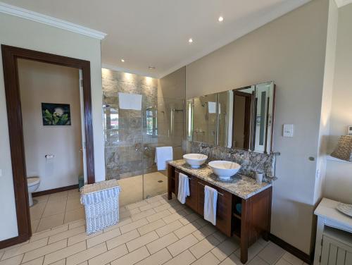 łazienka z 2 umywalkami i dużym lustrem w obiekcie Eden Island Apartment Citronelle w mieście Eden Island