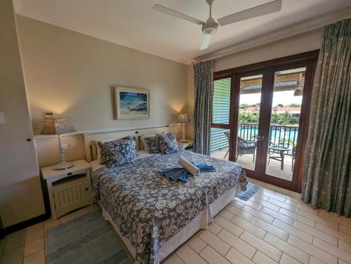 a bedroom with a bed and a balcony at Eden Island Apartment Citronelle in Eden Island