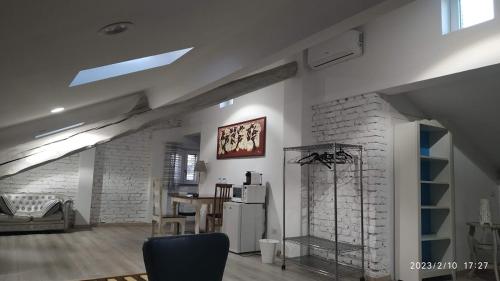 Mansarda Pascoli في Malnate: مطبخ وغرفة معيشة مع ثلاجة وطاولة