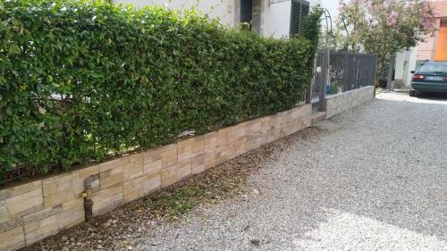 eine Hecke an der Seite einer Ziegelmauer in der Unterkunft Mansarda Pascoli in Malnate