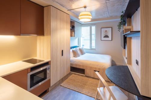 Ce petit appartement comprend un lit et une table. dans l'établissement Studio at Florence Dock, à Londres