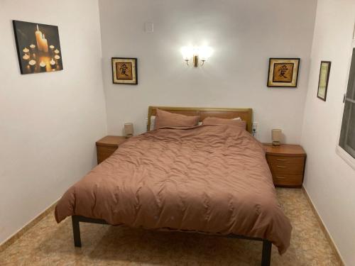 a bed in a bedroom with two night stands and two tables at El Milagro in L'Ampolla