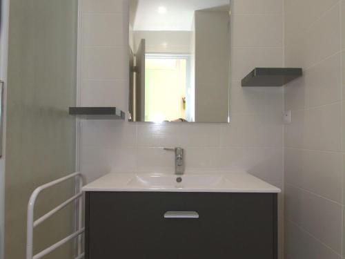 une salle de bain avec un lavabo et un miroir dans l'établissement Charmant T1 avec balcon, climatisation, et parking - Face Parc Charles de Gaulle - Balaruc-les-Bains - FR-1-553-147, à Balaruc-les-Bains