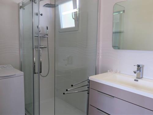 uma casa de banho com uma cabina de duche em vidro e um lavatório. em Maison Perros-Guirec, 3 pièces, 4 personnes - FR-1-368-301 em Perros-Guirec