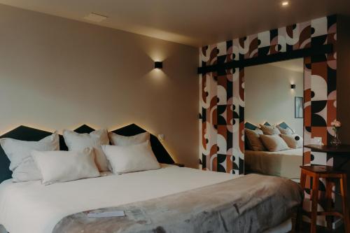 Un dormitorio con una cama grande con almohadas blancas. en Le Central Hôtel-Bar, en Oloron-Sainte-Marie