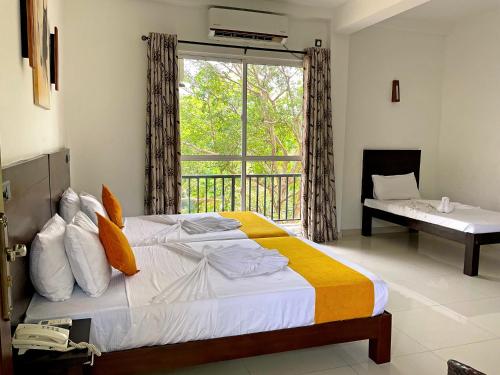 卡塔拉伽馬的住宿－Grand Detagamuwa，一间卧室设有一张大床和一个窗户。