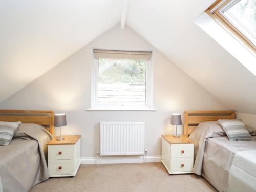 a attic bedroom with two beds and a window at The Brambles in Monmouth