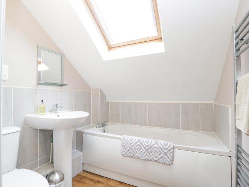 a white bathroom with a sink and a bath tub at The Brambles in Monmouth