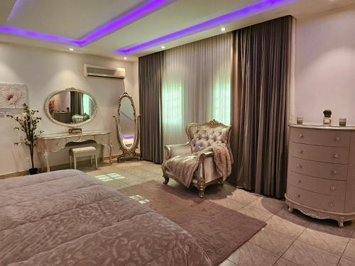 um quarto com uma cama, uma cadeira e um espelho em Friends em Riyadh