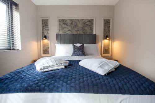 a bedroom with a large blue bed with two pillows at The Abbeygate Townhouse in Galway
