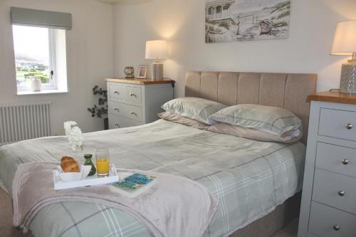 sypialnia z łóżkiem z tacą z jedzeniem w obiekcie Seaside Cottage 2 Bedroom - Bron-Y-Wendon Holiday Park w mieście Llanddulas
