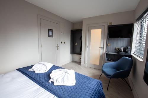 a bedroom with a bed with blue sheets and a blue chair at The Abbeygate Townhouse in Galway