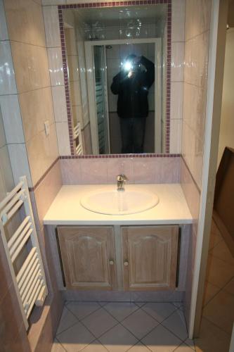 une personne prenant une photo d'un lavabo dans une salle de bains dans l'établissement BEAU STUDIO CLIMATISE PROXIMITE PORTS ET PLAGES, à La Ciotat