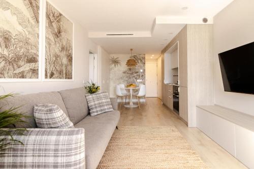 a living room with a couch and a dining room at Las Canteras con Alma in Las Palmas de Gran Canaria