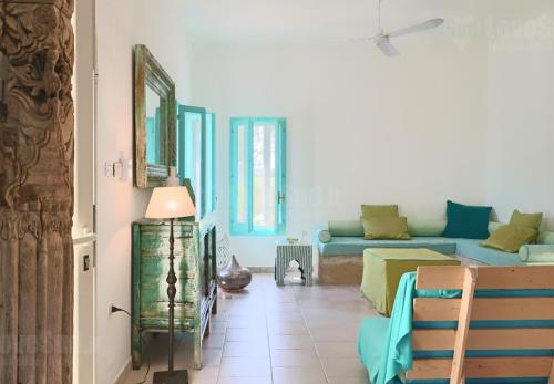 ein Wohnzimmer mit einem Sofa und einem Tisch in der Unterkunft La Casa del Pittore in Gagliano del Capo