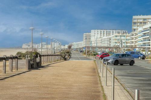 un aparcamiento junto a una playa con coches aparcados en Chambre sous les mimosas 2kms plage, en Saint-Jean-de-Monts