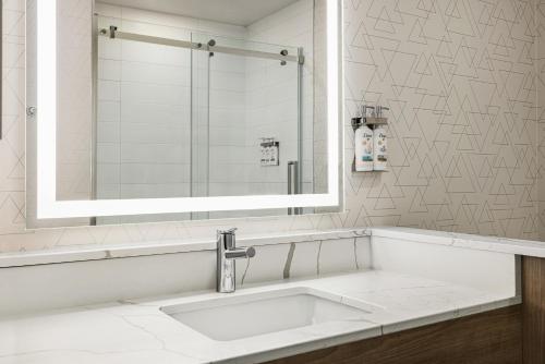 a bathroom with a sink and a mirror at Holiday Inn Express - Strathroy, an IHG Hotel in Strathroy