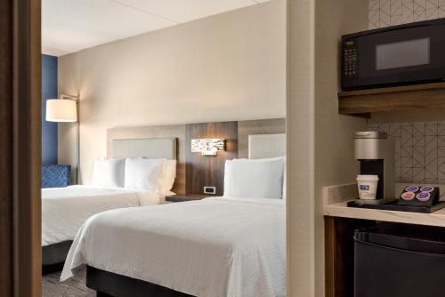 a hotel room with two beds and a flat screen tv at Holiday Inn Express - Strathroy by IHG in Strathroy