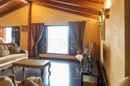 a living room with a couch and a table and a window at Angoni Villa in Durrës