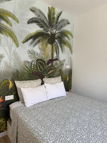 ein Schlafzimmer mit einem Bett mit einem Palmenmilch in der Unterkunft Casa RAFFAELLA - Habitat - Near YUMBO in Maspalomas