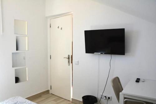 a room with a door with a television on the wall at Blife Faro Beach Hostel & Rooms in Faro