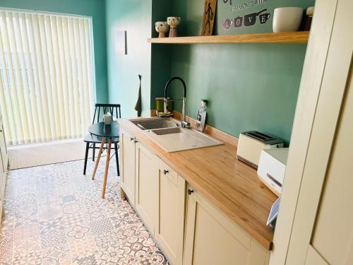 cocina con fregadero y encimera de madera en The Heath Retreat, en Whitstable