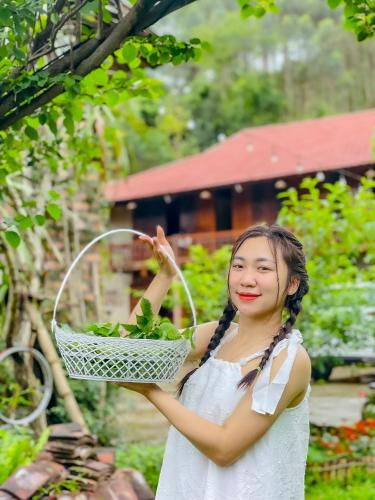 Lạng Sơn的住宿－Homestay Yến Long，一位年轻的女人拿着一篮子的绿