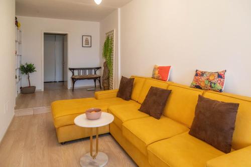 a yellow couch in a living room with a table at Angoni Villa in Durrës
