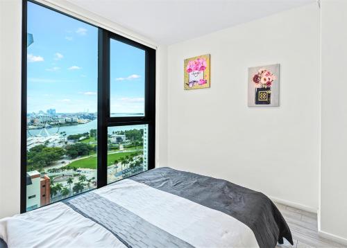 a bedroom with a bed and a large window at Experience the perfect Miami Life!! Centrally located Luxury Condo! in Miami
