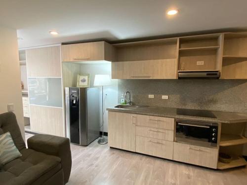 a kitchen with a couch and a refrigerator in a room at Lovely 1-bedroom apartment at Chapinero's heart in Bogotá