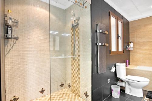 a bathroom with a toilet and a glass shower at Somni in Jávea