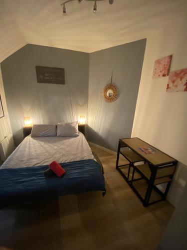 a bedroom with a bed and a side table at F1 Meublé et Confortable en cœur de ville in Longjumeau