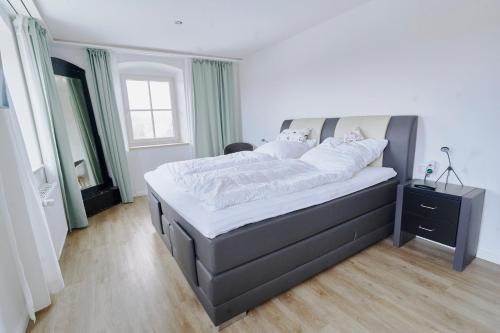a bedroom with a large bed with white sheets at Gasthof zur Post Saulgrub in Saulgrub