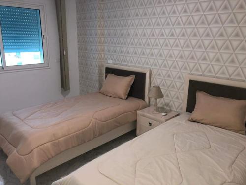 dos camas sentadas una al lado de la otra en un dormitorio en LUX & VIP apartment at Berges du Lac 2 Tunis en La Goulette