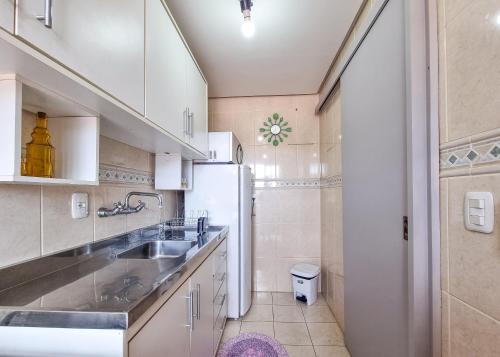 a kitchen with a sink and a refrigerator at Lar da Malú in Canela