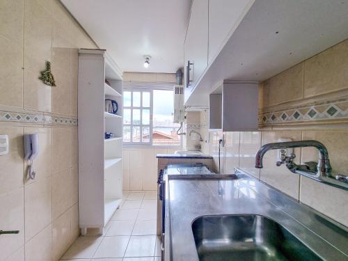 a large kitchen with a sink and a window at Lar da Malú in Canela