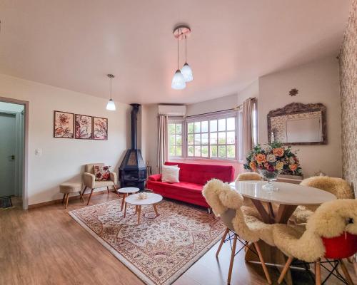 a living room with a red couch and a table at Lar da Malú in Canela