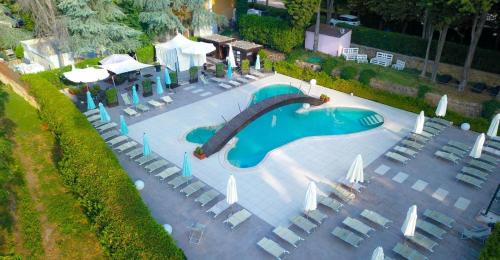an overhead view of a swimming pool with chairs and umbrellas at LH Hotel Excel Roma Montemario in Rome