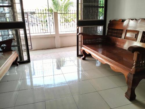 um banco de madeira sentado em cima de um piso de azulejo em Peekaboo house em Ubon Ratchathani