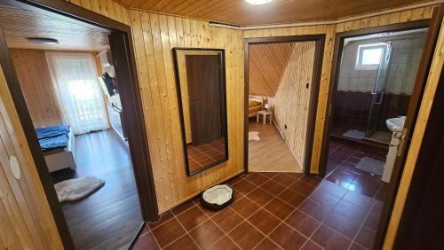 a bathroom with a shower and a toilet and a mirror at Reni Home Apartman in Balatonendréd