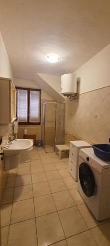 a bathroom with a sink and a washing machine at Affittacamere Due Passi e Il Mare in Castel di Tusa