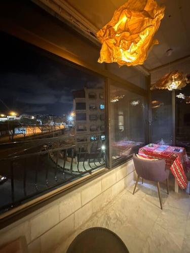 a dining room with a table and a window with a view at 3bedroom apart at-Al Kursi in Amman