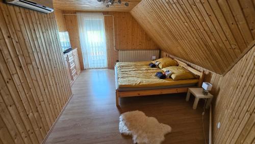 a bedroom with a bed in a wooden room at Reni Home Apartman in Balatonendréd