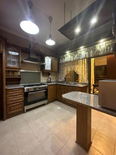 a large kitchen with wooden cabinets and a counter top at 3bedroom apart at-Al Kursi in Amman