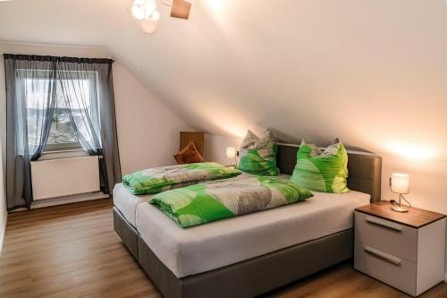 a bedroom with a large bed with green pillows at Haus Tanja in Freudenstadt