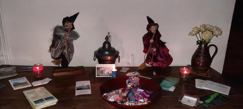 a table with figurines of witches and candles on it at Les Vagabonds du Mont in Chichilianne