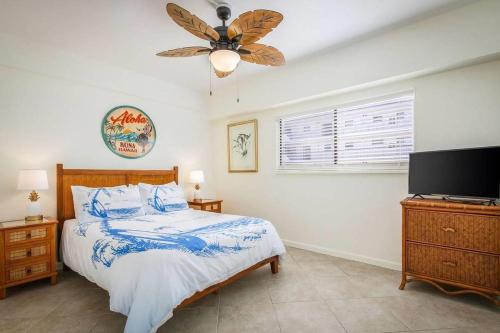 Un dormitorio con una cama y un ventilador de techo. en Kona Plaza#218, en Kailua-Kona