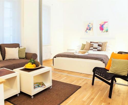 - un salon avec un lit et un canapé dans l'établissement Apartments Centro, à Belgrade
